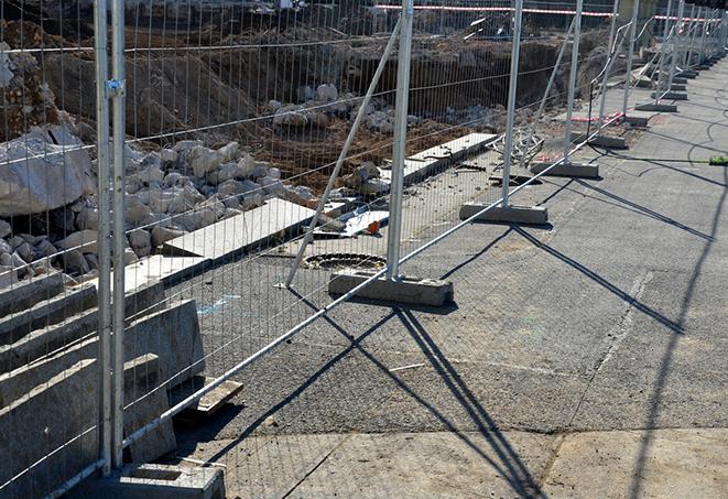 a temporary fence panel being used to secure and protect a public swimming pool area